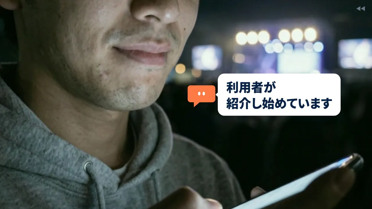 最終版の創業者の口元。くすみやひげの剃り跡のあるマットな肌で、背景にステージと群衆の影